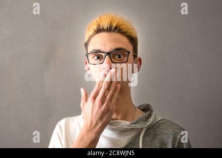 Ein Junge, der seine Hand vor seinen Mund legt Stockfoto