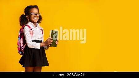 Happy Black Schulmädchen Posiert Mit Buch Auf Gelbem Hintergrund, Panorama Stockfoto