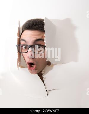 Ein Junge mit Kopf in einem zerrissenen weißen Karton Stockfoto