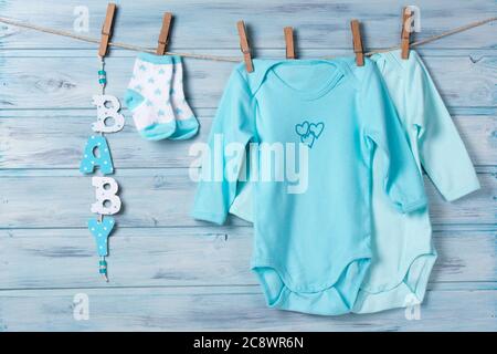 Babykleidung, kleine Socken und Wortbaby auf einer Wäscheleine Stockfoto