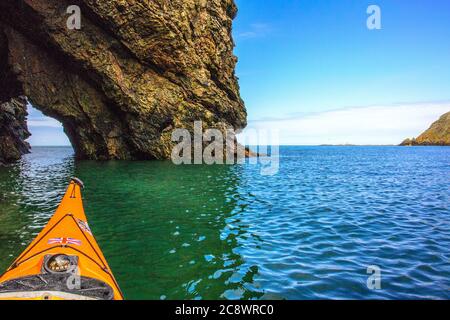 Kajakfahren auf dem Meer bei Ynys y Fydlyn vor der Anglesey-Küste, North Wales, Großbritannien Stockfoto