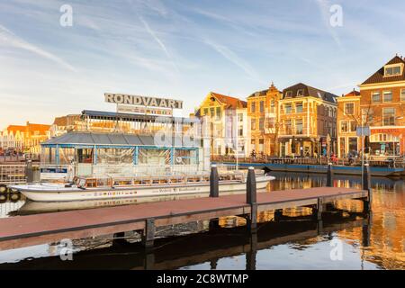 Leiden, Niederlande - 16. Januar 2020: Blick auf den niederländischen Galgewater-Kanal mit Kreuzfahrtschiff bei Sonnenuntergang im alten Stadtzentrum von Leiden Stockfoto