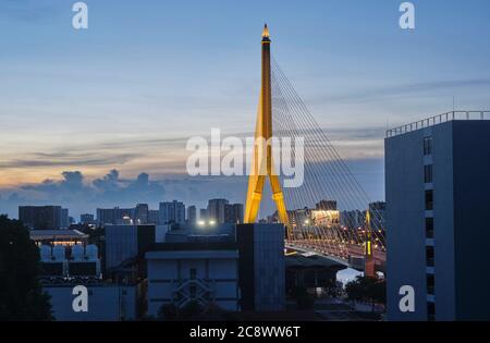 Die 475 m lange Rama VIII. Bridge, eine Hängebrücke über den Chao Phraya Fluss in Bangkok, Thailand, beleuchtet in der Dämmerung kurz nach Sonnenuntergang Stockfoto