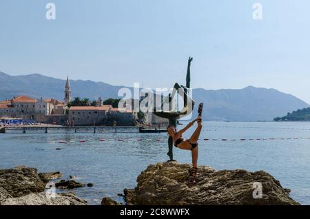 Tourist posiert für ein Foto in der Nähe der Statue Stockfoto