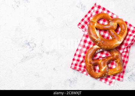 Zwei Brezeln auf einem karierten Handtuch, Biersnack, Draufsicht mit Kopierplatz Stockfoto