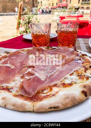 Pizza mit Prosciutto und Gläser aperol Spritz in Italien Stockfoto