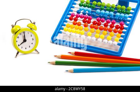 Gelbe Uhr, ein Abakus und bunte Stifte auf weißem Hintergrund - Konzept der Bildung Stockfoto