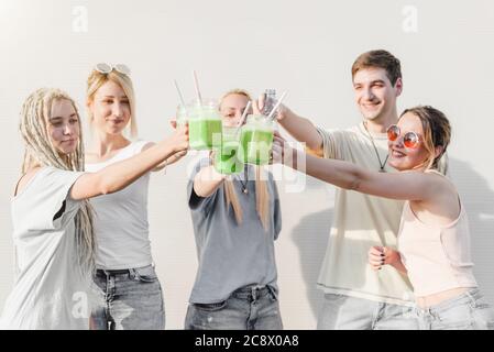 Gruppe von jungen Leuten mit grünen Bio-Smoothie-Getränken toasten Stockfoto
