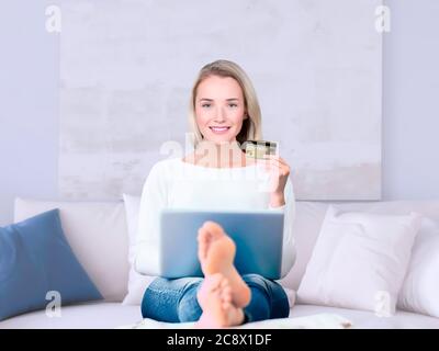 Porträt einer jungen Frau mit Laptop und Kreditkarte Stockfoto