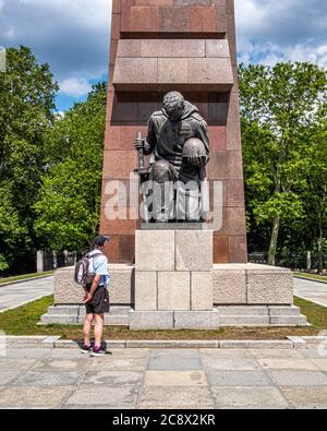 Bronze kniende Soldatenskulptur vor abstrakter Granitfahne am Sowjetischen Kriegsdenkmal im Treptow Park, Berlin, Deutschland Stockfoto