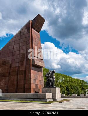 Bronze kniende Soldatenskulptur vor abstrakter Granitfahne am Sowjetischen Kriegsdenkmal im Treptow Park, Berlin, Deutschland Stockfoto