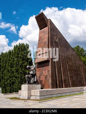 Bronze kniende Soldatenskulptur vor abstrakter Granitfahne am Sowjetischen Kriegsdenkmal im Treptow Park, Berlin, Deutschland Stockfoto