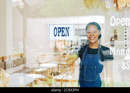 Lächelnd junge Black kleine Café-Besitzer glücklich, Bäckerei nach Quarantäne-Zeit zu öffnen Stockfoto