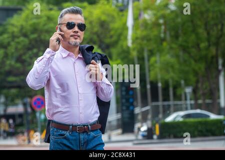 Telefongeschäft im Freien bei Männern mittleren Alters Stockfoto