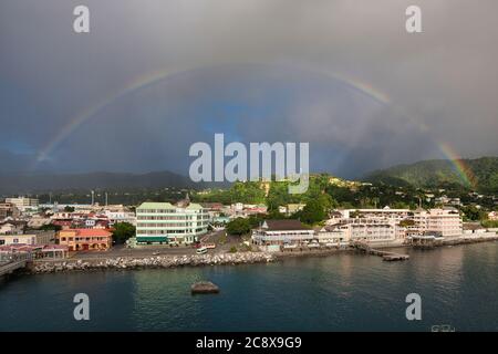 Regenbogen über der Stadt Roseau auf der Insel Dominica in der Karibik mit der Uferpromenade und Gebäuden in Anzeigen Stockfoto