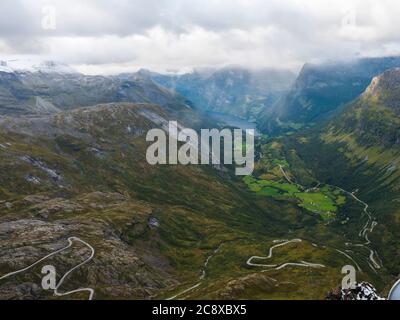 Luftaufnahme auf Geirangerfjord Fjord mit Geiranger Touristendorf und Kreuzfahrtschiff, UNESCO-Weltkulturerbe. Blick vom Aussichtspunkt Dalsnibba Skywalk Stockfoto