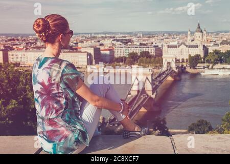 Junge Frau sitzt in Budapest Panorama, Rückansicht, Ungarn Stockfoto