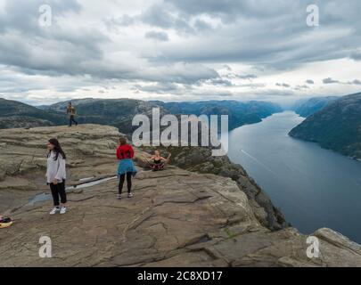 Songesand, Norwegen, 9. September 2019: Gruppe junger Mädchen posiert auf Foto am Preikestolen massive Klippe am Fjord Lysefjord. Moody Herbsttag Stockfoto