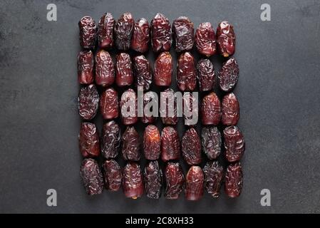 Trockene Medjool-Dates Auf Schwarzem Schiefer-Hintergrund. Gruppe getrockneter Datter Früchte. Arabisches Essen Stockfoto