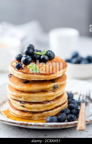 Heidelbeer Pfannkuchen Stapel mit Blumenhonig gegossen. Leckere Pfannkuchen mit Heidelbeeren Stockfoto