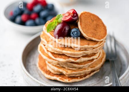 Gesunde Haferpfannkuchen mit Beeren auf einem Teller. Vegane glutenfreie Pfannkuchen Stockfoto