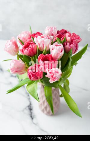 Bouquet von rosa Pfingstrosen Tulpen in Vase. Weihnachtsblumen Blumenstrauß, Hochzeit oder 8 März Konzept Stockfoto
