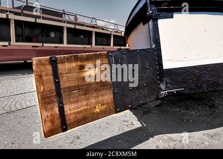 Hölzerne quadratische Ruderblatt auf einem Lastkahn, der auf trockenem Land liegt Stockfoto