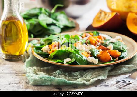 Gerösteter Kürbissalat mit Spinat, Feta und Pinienkernen. Herbstgericht Stockfoto