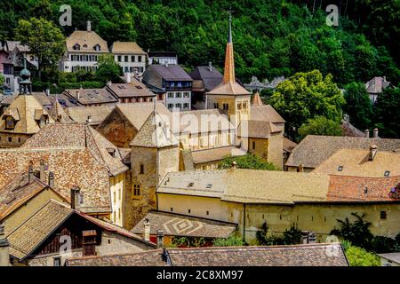 Panoramablick auf die romanische Stiftskirche in der mittelalterlichen Stadt Romainmotier, Kanton Waadt, Schweiz. Stockfoto