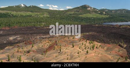 Bunte Landschaft mit roter, oranger Asche, Lavabetten und blauem See in Painted Dunes im Lassen National Forest Stockfoto