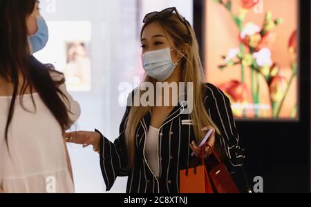 Hongkong, CHINA. Juli 2020. Modische weibliche Shopper chatten mit ihrem Freund in High-Class-Shopping-Arcade.Mandatory Maske tragen wird nun auf alle Bürger in allen Innenräumen inmitten der anhaltenden Ausbreitung von Coronavirus in der Stadt, die explodiert mit alarmierender Geschwindigkeit auferlegt.Juli-27, 2020 Hong Kong.ZUMA/Liau Chung-ren Kredit: Liau Chung-ren/ZUMA Wire/Alamy Live News Stockfoto