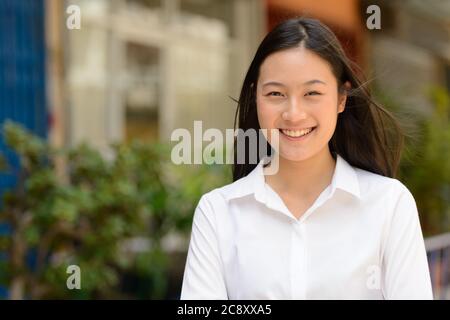 Porträt von jungen schönen asiatischen Geschäftsfrau im Freien Stockfoto