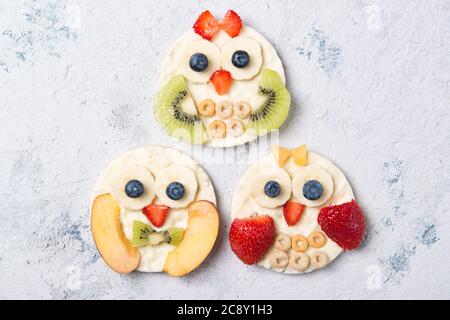 Reiskuchen mit Joghurt und frischem Obst in Formen von niedlichen Eulen, Mahlzeit für Kinder Idee, Draufsicht Stockfoto