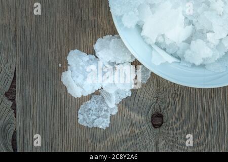 Blume griechischer Meersalzkristalle, Südkreta. Natürliche traditionelle Fleur de Sel von Kreta. Meersalzflocken auf Holzbakkboden. Stockfoto