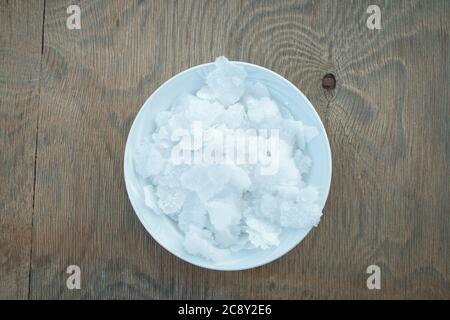 Blume griechischer Meersalzkristalle, Südkreta. Natürliche traditionelle Fleur de Sel von Kreta. Meersalzflocken auf Holzbakkboden. Stockfoto