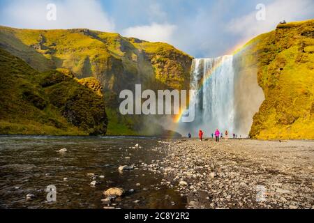 Skogafoss Wasserfall und Regenbogen am sonnigen Herbsttag, Island. Große touristische Attraktion, Stockfoto