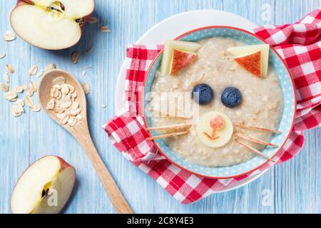 Lustige Haferbrei mit Katze, Kätzchen Gesicht aus Obst und Beeren, Futter für Kinder Idee, Draufsicht Stockfoto