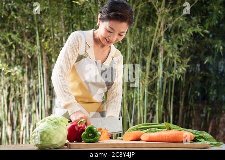 Der Hof hackt Gemüse in Midlife Frauen Stockfoto