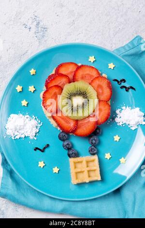 Süße Waffeln mit Früchten in Form eines Luftballons am Himmel, Mahlzeit für Kinder Idee, Draufsicht Stockfoto