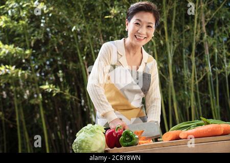 Der Hof hackt Gemüse in Midlife Frauen Stockfoto