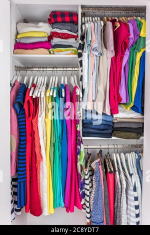 Hausschrank organisierte begehbare Schlafzimmer Kleiderschrank von Frauen Mode Kleidung hängen auf Regalen. Sommerlicher Style, Kleider und T-Shirts Stockfoto