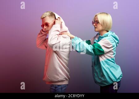 Relathions Probleme zwischen zwei liebenden Menschen. Studio Schuss der jungen blonden Frau in Outdoor-trendige Jacke Unterstützung deprimiert beleidigt boyfri gekleidet Stockfoto