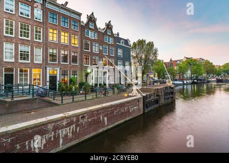 Amsterdamer Straßen und Kanäle in der Abenddämmerung, Sommersaison. Sint Antoniesluis, beliebtes Reiseziel für Touristen. Stockfoto