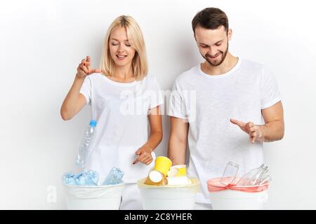 Junge fröhlich glückliche Frau und Mann trennen Abfall und Recycling am Arbeitsplatz, gute Gewohnheit Stockfoto