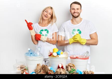 Junge Leute sind bereit, Müll zu sortieren, Frau setzt Handschuhe an, bevor Müll recycelt, Nahaufnahme Porträt Stockfoto