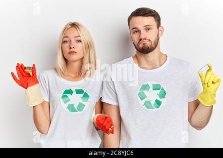 Nahaufnahme von schweren unglücklich traurig Mann und Frau in roten und gelben Handschuhen mit Alkali-Batterien .Umwelt und Ökologie Konzept. Nahaufnahme Porträt, Stockfoto