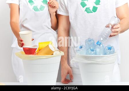 Junge Frau und Frau Vorbereitung Wurf zu recyceln und wiederverwenden. Close up beschnitten Foto. Isoliert weißen Hintergrund. 3R s Recycling Stockfoto