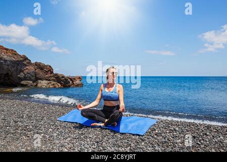 Junge Frau macht Yoga an der Küste in Griechenland Stockfoto