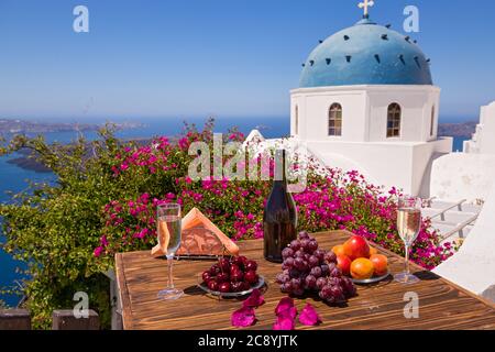 Wein und Obst für zwei auf dem Tisch vor dem Hintergrund des Meeres von Santorini Stockfoto