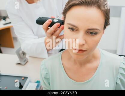 Weibliche Patientin mit Ohrenspiegelung in der Praxis eines Audiologen. Nahaufnahme. Hörklinik Stockfoto